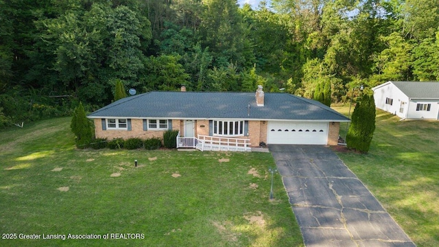 15988 Comdon Rd, Albion, MI 49224 - ranch-style house with asphalt driveway, brick siding, a garage, a chimney, and a front yard