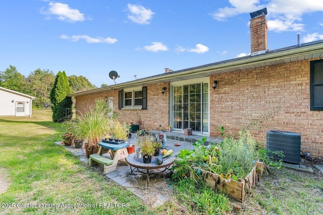 15988 Comdon Rd, Albion, MI 49224 - rear view of house featuring cooling unit, a yard, brick siding, a chimney, and a patio area