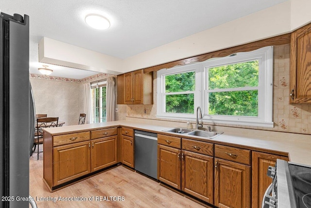 15988 Comdon Rd, Albion, MI 49224 - kitchen with a sink, appliances with stainless steel finishes, light countertops, light wood-style flooring, and brown cabinetry