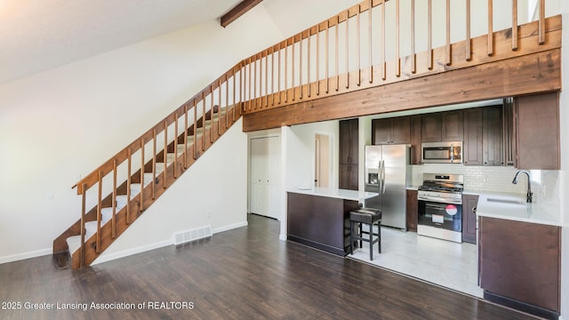 4918 Westhaven Blvd, Lansing, MI 48917 - kitchen with stainless steel appliances, a sink, high vaulted ceiling, light countertops, and decorative backsplash