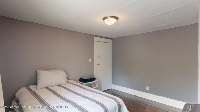 1023 Bement St, Lansing, MI 48912 - bedroom with dark wood-style flooring and baseboards