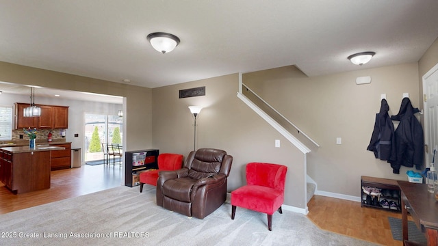 1055 Oakwood Dr, Dewitt, MI 48820 - living area with stairs and light wood-style floors