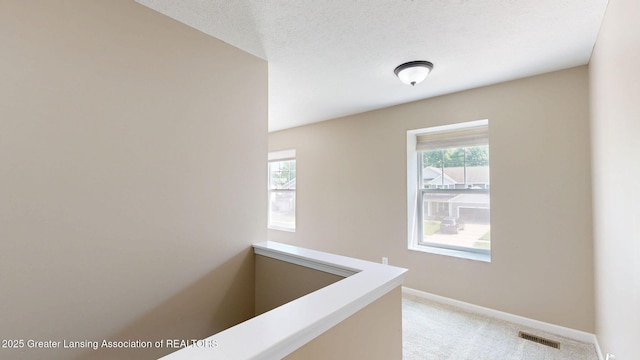 1055 Oakwood Dr, Dewitt, MI 48820 - hall featuring healthy amount of natural light, light carpet, and baseboards