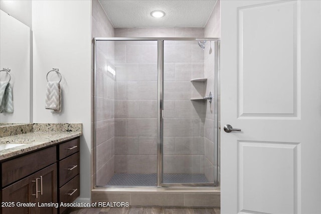 5651 Copper Creek Dr, Haslett, MI 48840 - full bathroom with a stall shower, a textured ceiling, and vanity