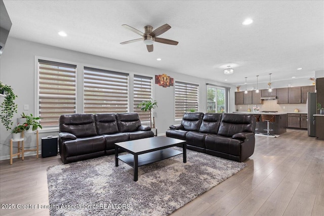 5651 Copper Creek Dr, Haslett, MI 48840 - living area featuring ceiling fan, recessed lighting, light wood-type flooring, a textured ceiling, and baseboards