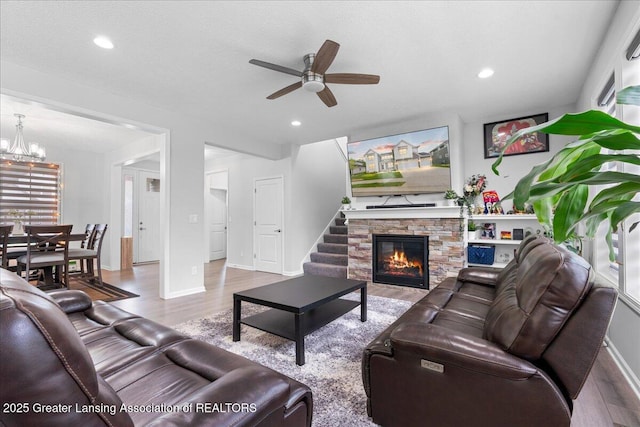 5651 Copper Creek Dr, Haslett, MI 48840 - living area featuring wood finished floors, a ceiling fan, a chandelier, a fireplace, and recessed lighting