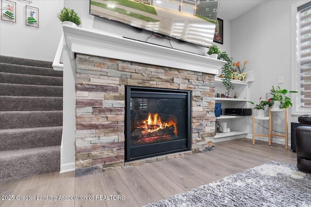 5651 Copper Creek Dr, Haslett, MI 48840 - detailed view of wood finished floors, a stone fireplace, and baseboards