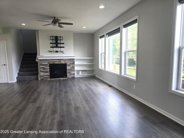 5651 Copper Creek Dr, Haslett, MI 48840 - unfurnished living room with a ceiling fan, a fireplace, dark wood-style flooring, stairs, and recessed lighting