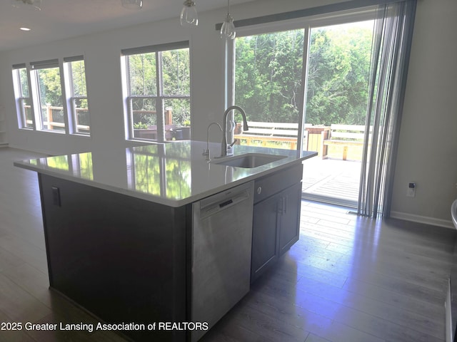 5651 Copper Creek Dr, Haslett, MI 48840 - kitchen featuring stainless steel dishwasher, hardwood / wood-style floors, light countertops, a center island with sink, and decorative light fixtures