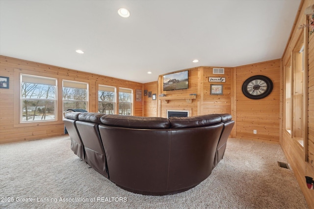 9671 Lakeside Dr, Perrinton, MI 48871 - living area featuring light carpet, wooden walls, a fireplace, and recessed lighting