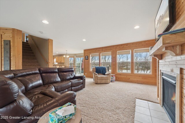 9671 Lakeside Dr, Perrinton, MI 48871 - living room featuring light carpet, stairway, a fireplace with flush hearth, recessed lighting, and wooden walls