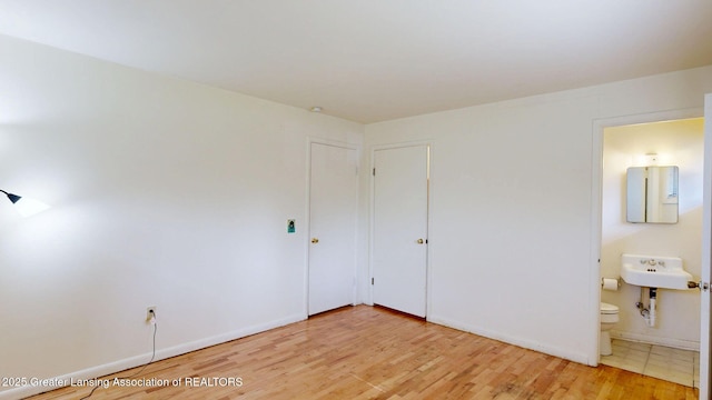 5120 Wardcliff Dr, East Lansing, MI 48823 - unfurnished bedroom featuring light wood-style flooring, ensuite bathroom, and baseboards