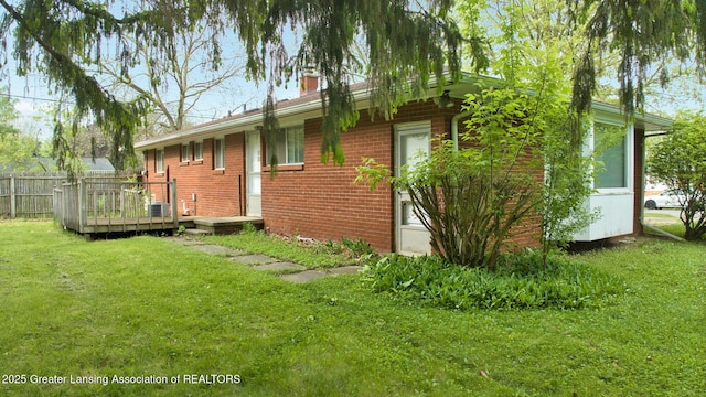 5120 Wardcliff Dr, East Lansing, MI 48823 - view of side of property with brick siding, a chimney, and a wooden deck