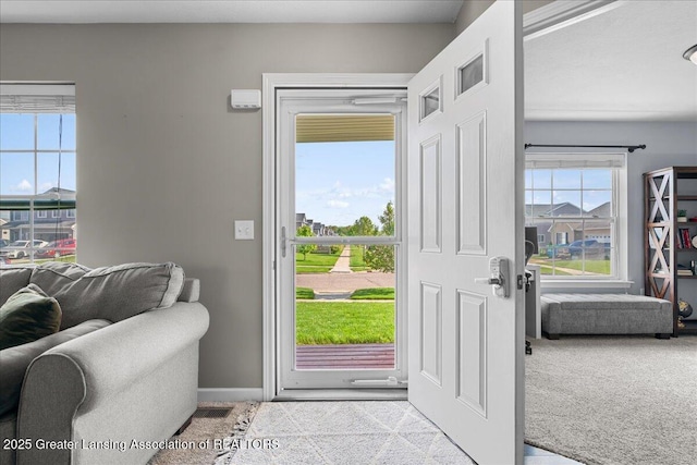doorway to outside with carpet, healthy amount of natural light, and baseboards