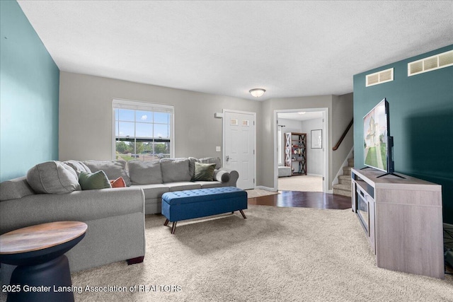 carpeted living area with stairway