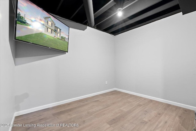 spare room featuring wood finished floors and baseboards