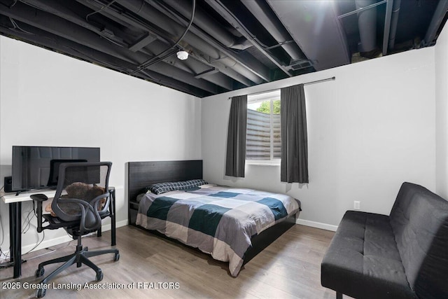 bedroom with wood finished floors and baseboards