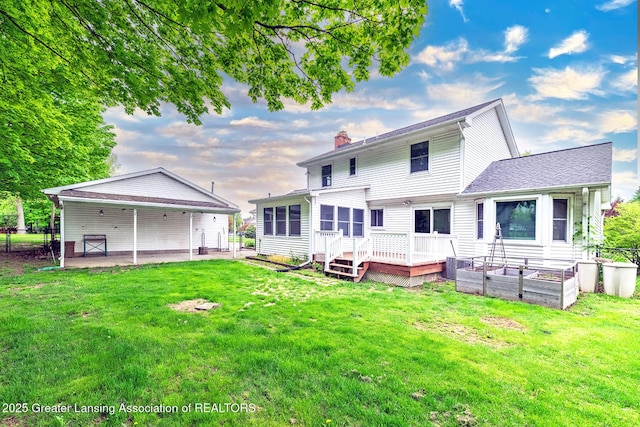 back of house featuring a chimney, a vegetable garden, a deck, and a patio area