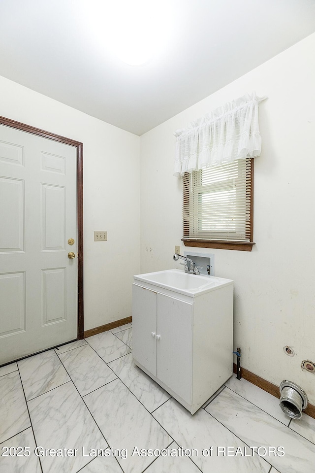 laundry area with light marble finish flooring, baseboards, and hookup for a washing machine