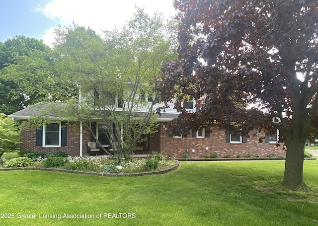 view of front of property with brick siding and a front lawn