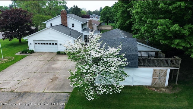 view of side of home featuring a shingled roof, concrete driveway, a yard, and a garage