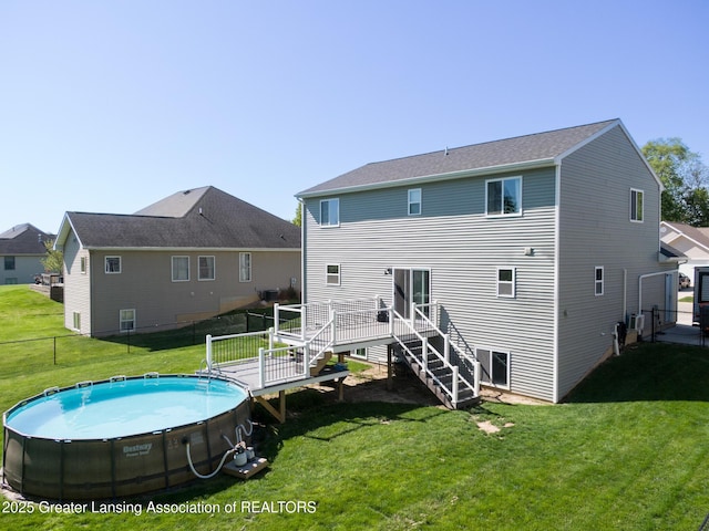 3793 Calypso Rd, Holt, MI 48842 - back of house featuring a wooden deck, stairway, an outdoor pool, and central AC unit