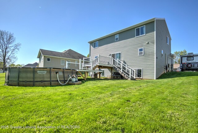 3793 Calypso Rd, Holt, MI 48842 - rear view of property with stairway, a yard, and a wooden deck