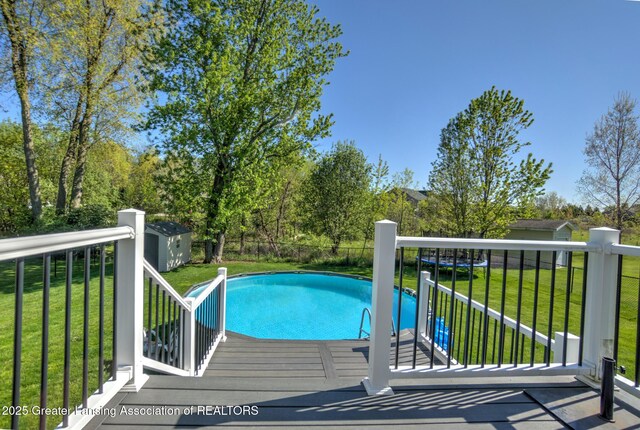 3793 Calypso Rd, Holt, MI 48842 - view of swimming pool featuring a storage unit, a lawn, and an outdoor structure