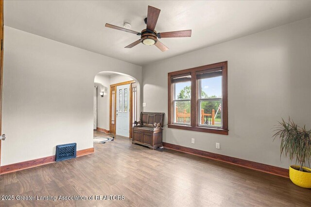 1614 Gunn Rd, Holt, MI 48842 - unfurnished room featuring arched walkways, wood finished floors, baseboards, and a ceiling fan