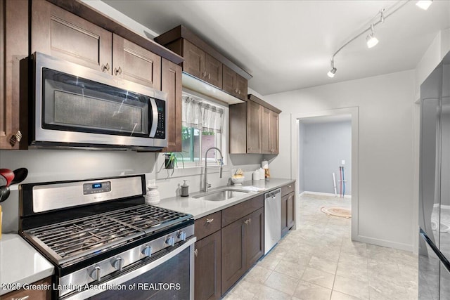 1614 Gunn Rd, Holt, MI 48842 - kitchen featuring stainless steel appliances, a sink, light countertops, dark brown cabinetry, and baseboards