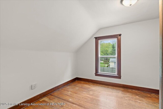 1614 Gunn Rd, Holt, MI 48842 - bonus room featuring vaulted ceiling, hardwood / wood-style flooring, and baseboards