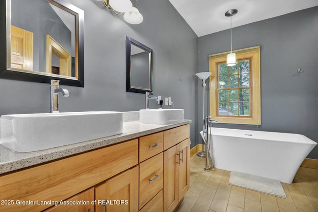 3650 Observatory Ln, Holt, MI 48842 - full bathroom featuring a soaking tub, baseboards, lofted ceiling, and double vanity