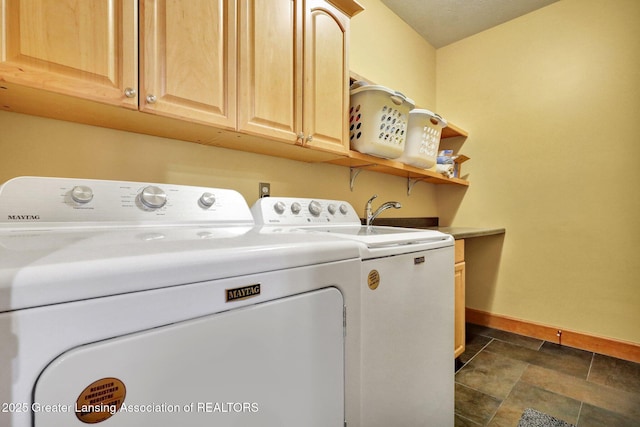 3650 Observatory Ln, Holt, MI 48842 - clothes washing area with separate washer and dryer, cabinet space, baseboards, and dark stone finish flooring