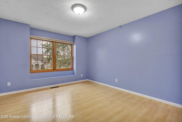 3650 Observatory Ln, Holt, MI 48842 - empty room with wood finished floors, baseboards, and a textured ceiling