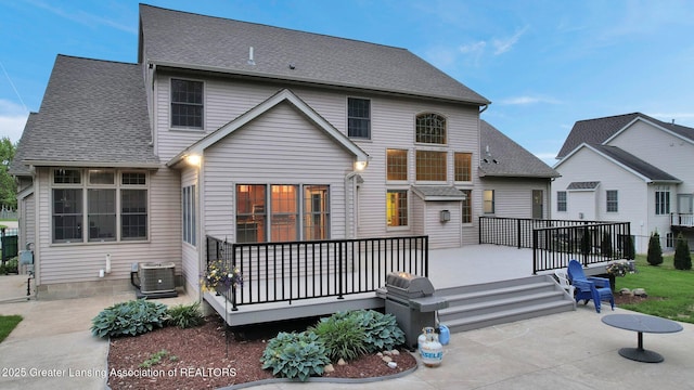 3650 Observatory Ln, Holt, MI 48842 - back of house featuring central AC, a deck, a shingled roof, and a patio