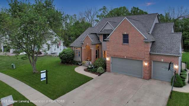 3650 Observatory Ln, Holt, MI 48842 - traditional-style house featuring brick siding, driveway, roof with shingles, a garage, and a front yard