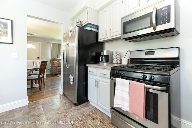 2531 Dillingham Ave, Lansing, MI 48906 - kitchen featuring appliances with stainless steel finishes, white cabinetry, light countertops, and baseboards
