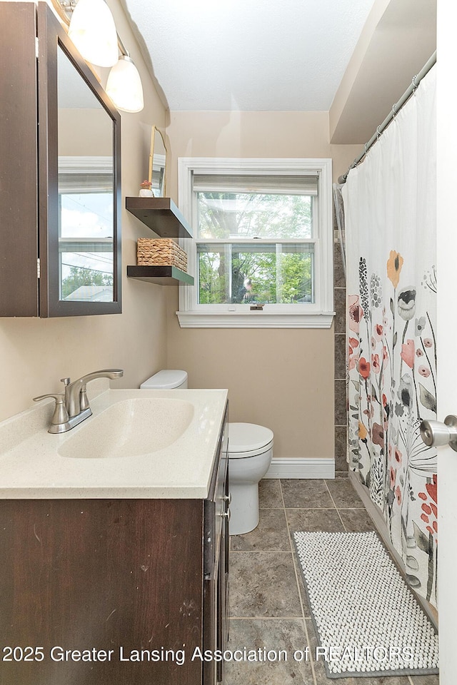 2531 Dillingham Ave, Lansing, MI 48906 - bathroom featuring toilet, vanity, baseboards, and curtained shower