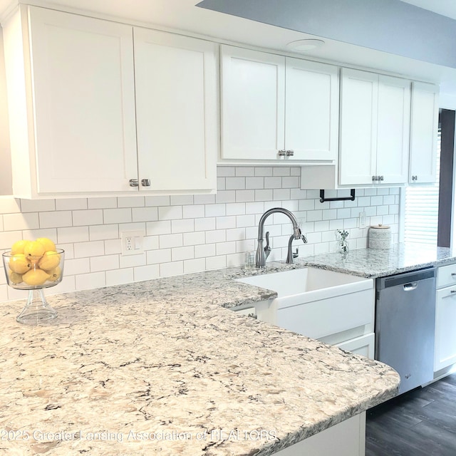 kitchen featuring dishwasher, a sink, and white cabinetry