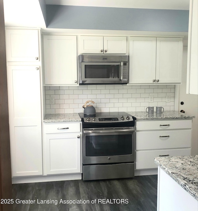 kitchen with stainless steel appliances, dark wood finished floors, white cabinetry, and decorative backsplash