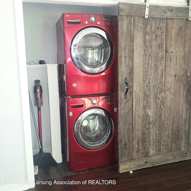 laundry area with stacked washer / dryer and wood finished floors
