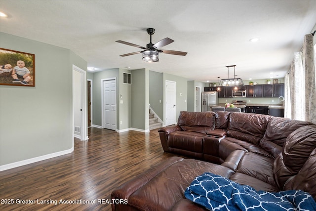 703 Josie Ln, Laingsburg, MI 48848 - living room with dark wood-style floors, stairway, baseboards, and a ceiling fan