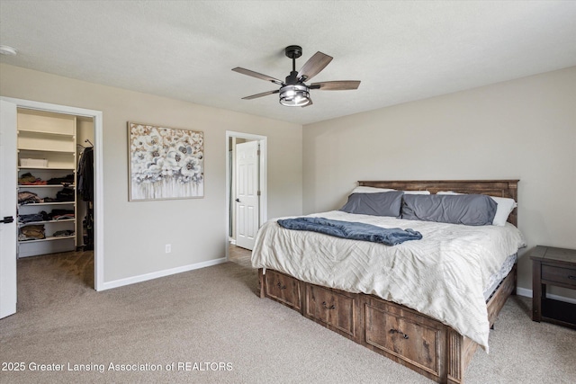 703 Josie Ln, Laingsburg, MI 48848 - bedroom with light carpet, a walk in closet, baseboards, a closet, and a ceiling fan