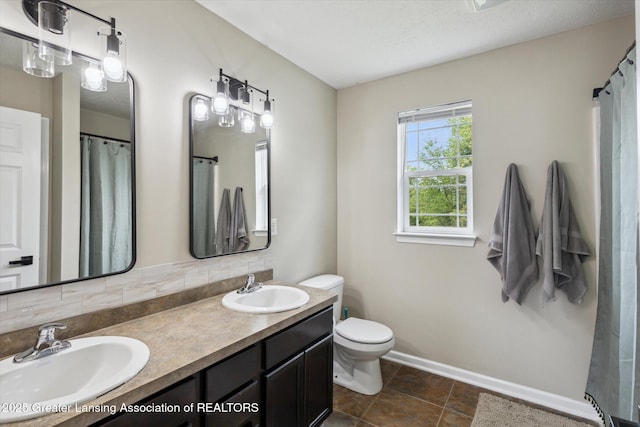 703 Josie Ln, Laingsburg, MI 48848 - bathroom featuring baseboards, toilet, and double vanity
