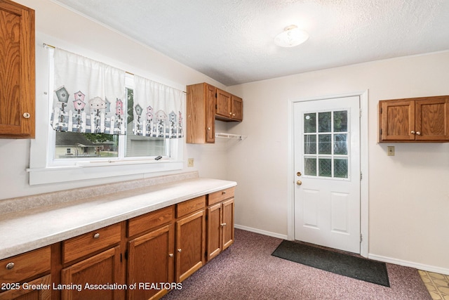 washroom with baseboards and a textured ceiling