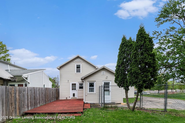 back of property featuring a deck and a gate