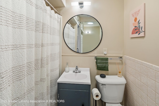 1038 Morgan St, Lansing, MI 48912 - bathroom with vanity, tile walls, toilet, and a wainscoted wall