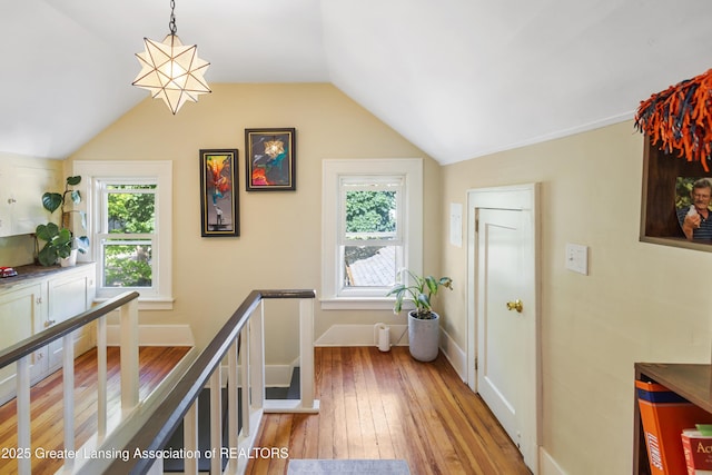 1038 Morgan St, Lansing, MI 48912 - hallway featuring wood-type flooring, vaulted ceiling, baseboards, and an upstairs landing