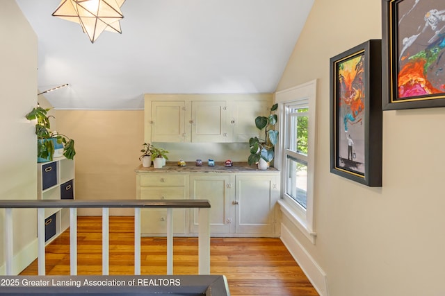 1038 Morgan St, Lansing, MI 48912 - bar area with vaulted ceiling, light wood-type flooring, and baseboards