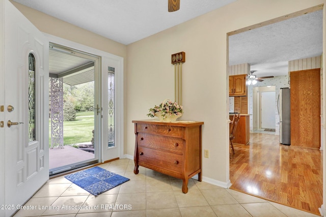 10079 Woodland Acres Dr, Grand Ledge, MI 48837 - foyer featuring a ceiling fan, light tile patterned flooring, and baseboards